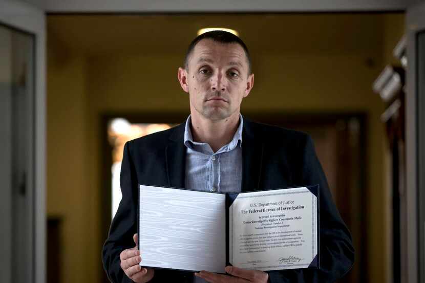 Constantin Malic,  a Moldovan investigator holding an award he received from the FBI, gulped...