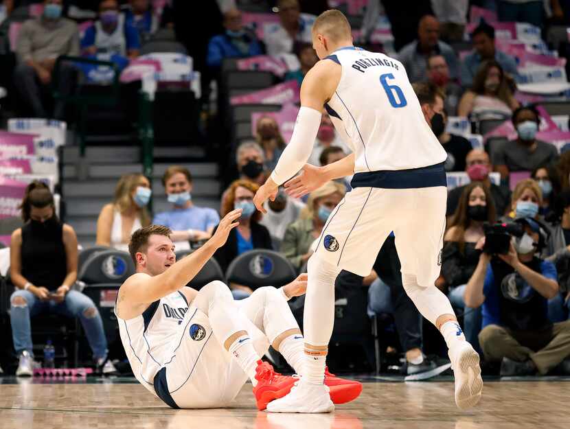 Dallas Mavericks center Kristaps Porzingis (6) helped teammate Luka Doncic (77) to his feet...