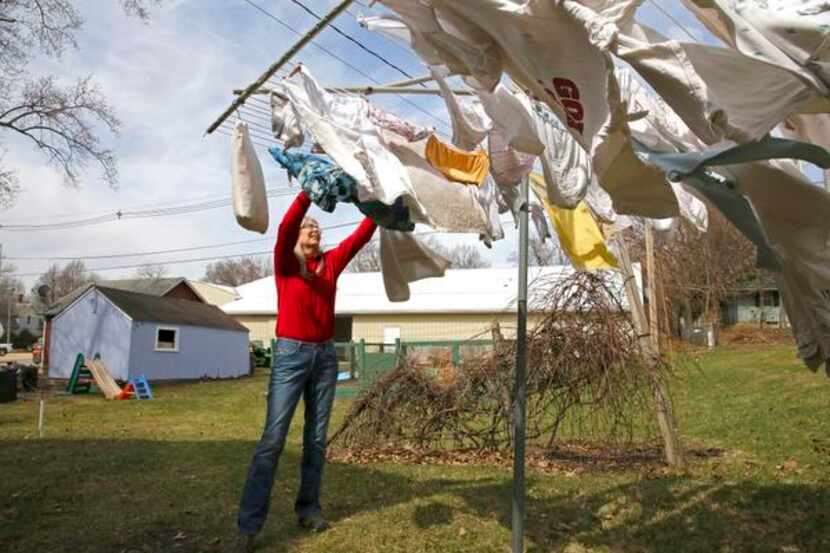 
Kathy Washburn of Mount Vernon, Iowa, hanging out laundry on her lunch break, earns $33,000...