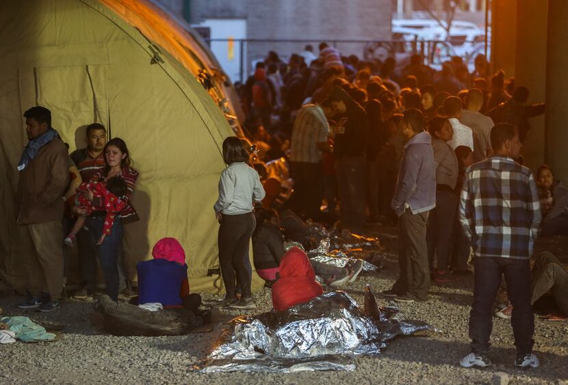 Migrants, including young children and babies, seeking asylum wait at a U.S. Border Patrol...