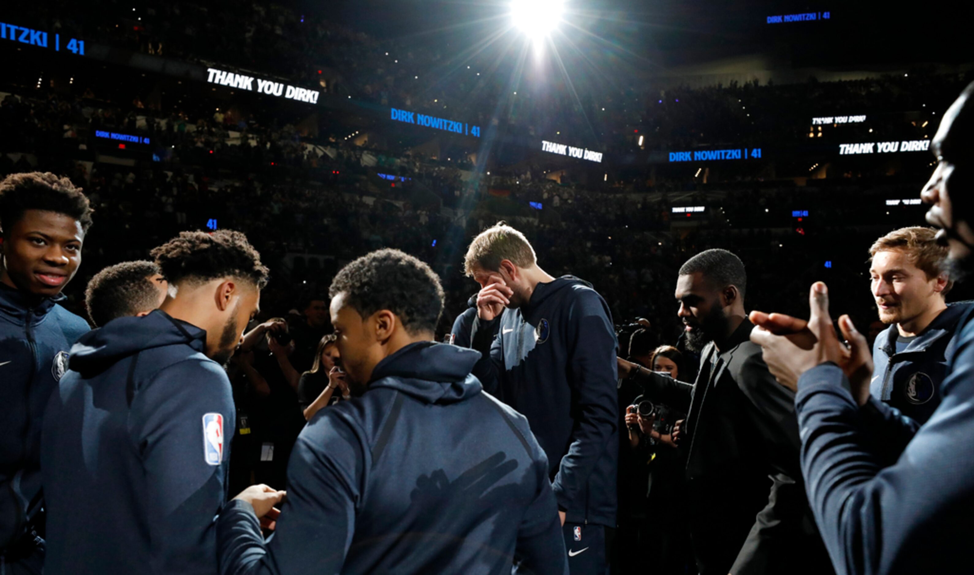 Dallas Mavericks' Dirk Nowitzki (center) cries during a video tribute before the game...