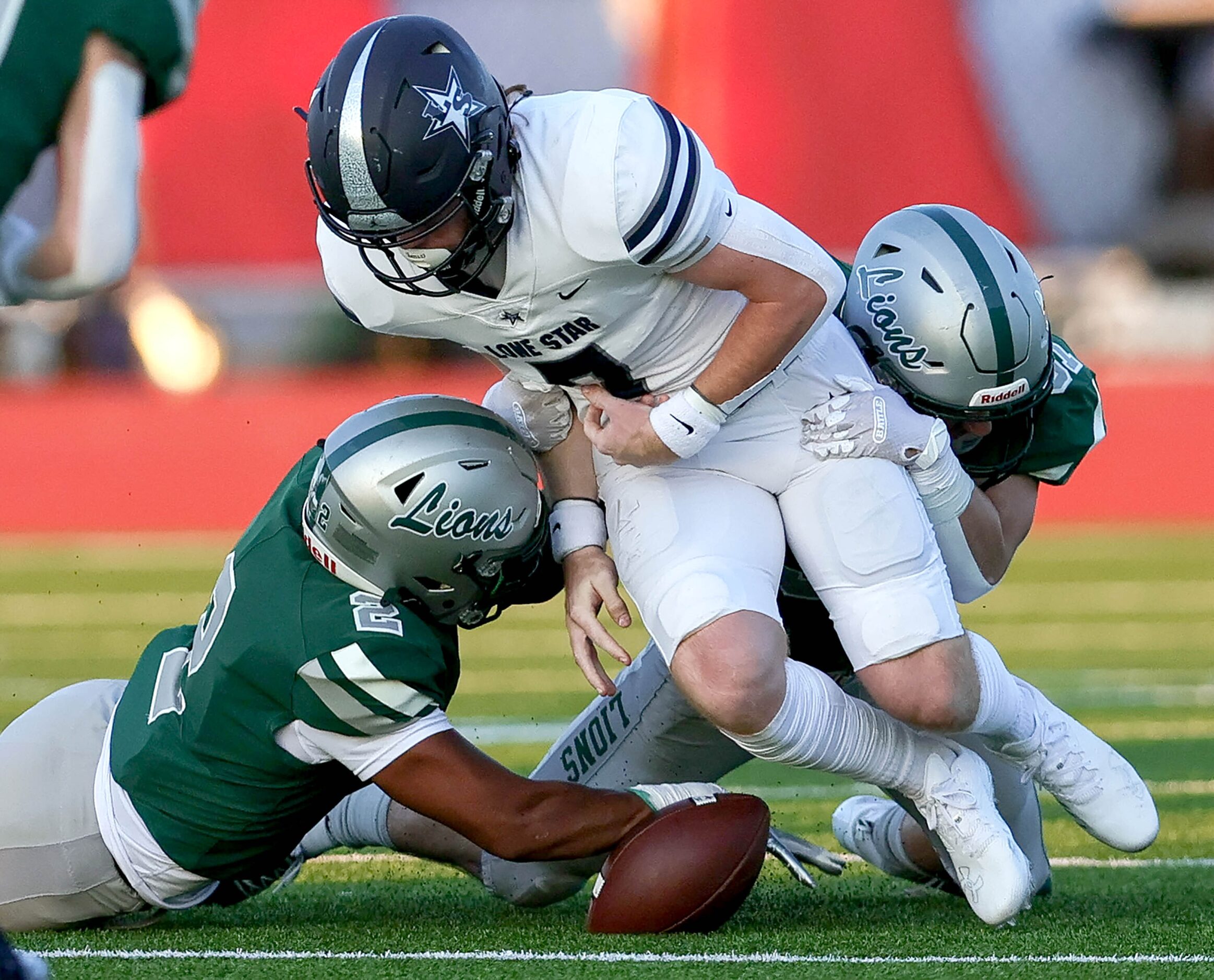 Frisco Lone Star quarterback Bennett Fryman (7) gets stripped from the ball by Frisco Reedy...