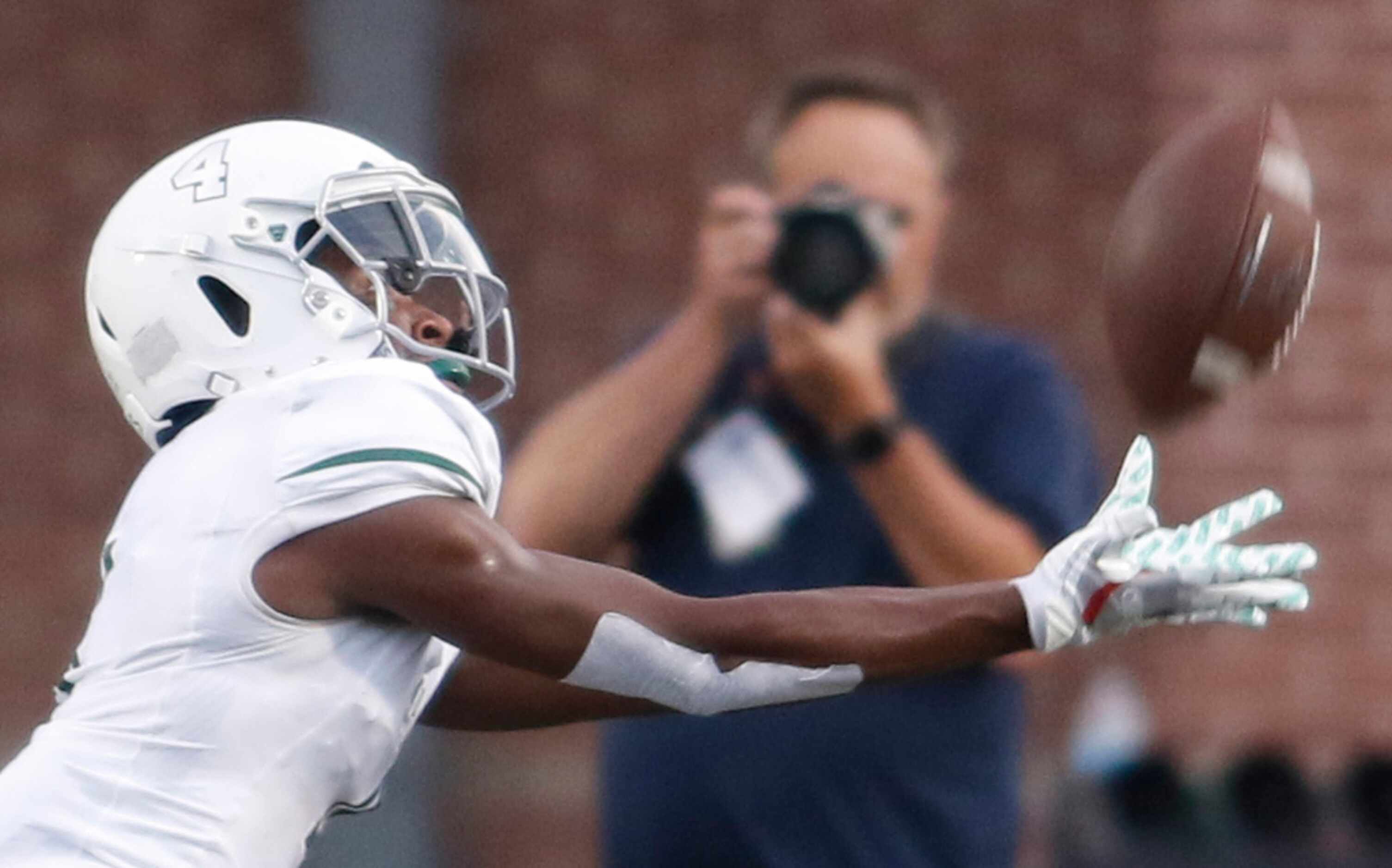 Prosper receiver Tyler Bailey (4) stretches to reach the ball during a first half punt...