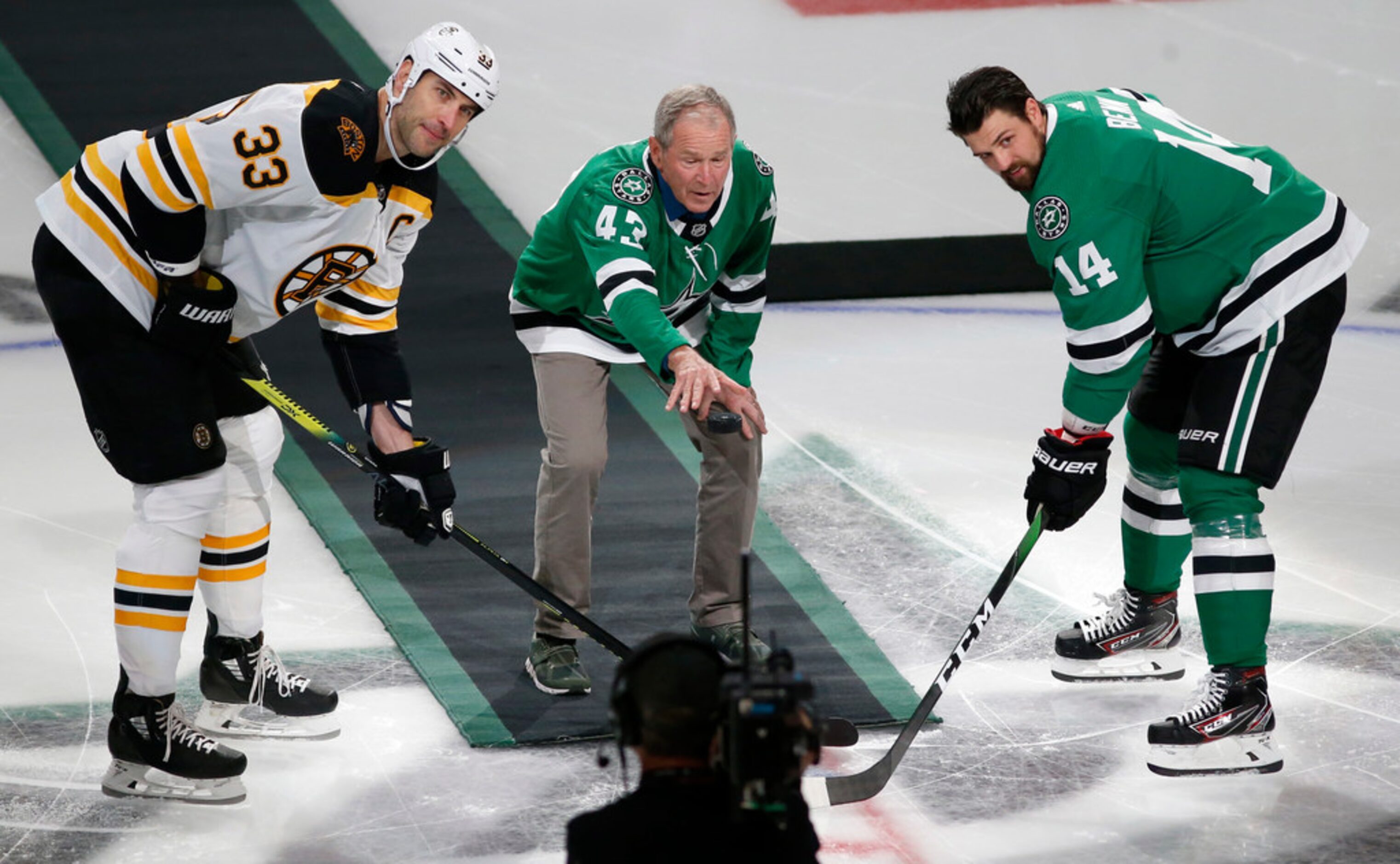 Former President George W. Bush drops the puck as Boston Bruins defenseman Zdeno Chara (33)...