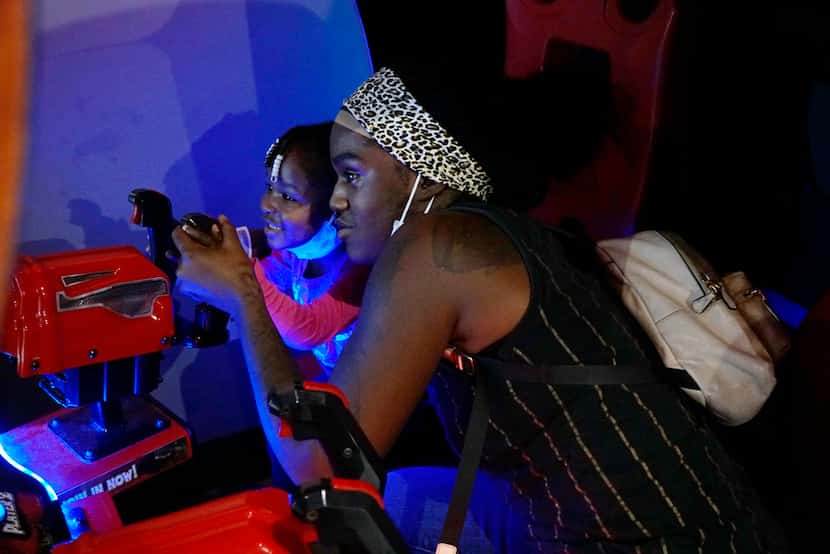 Queen Island, who's 2, and her mother Destinee Island play a video game during a fundraiser...