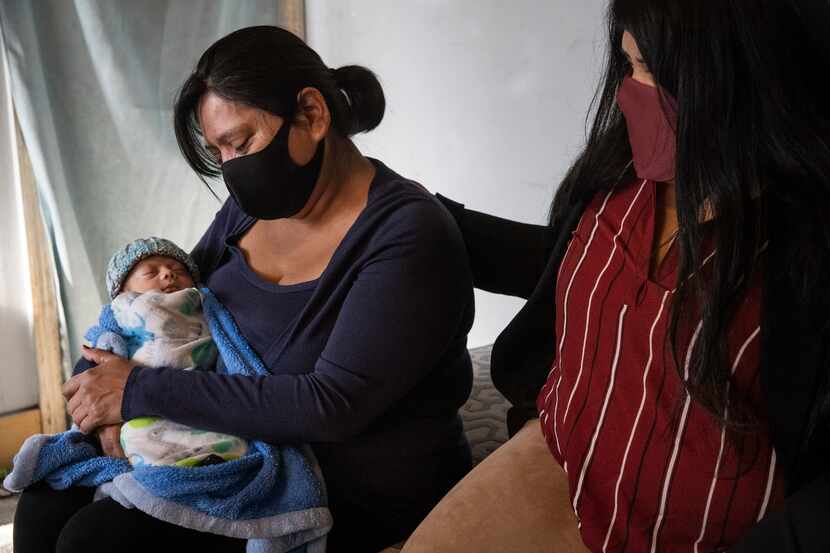 Lucy Palacios (der.), de 23 años, consuela a su madre Miriam mientras sujeta a su nieto de...