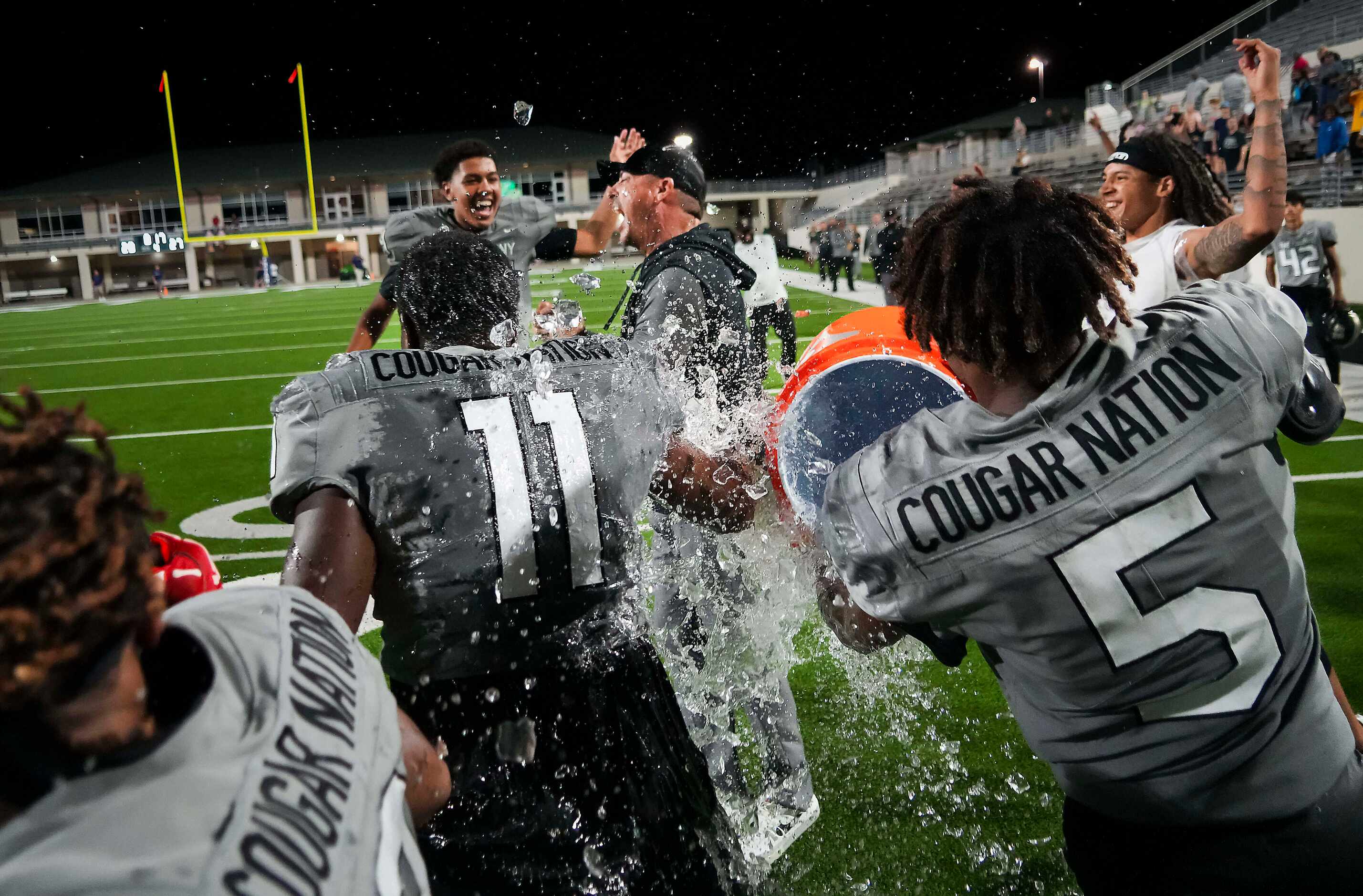 The Colony players douse head coach Rudy Rangel and defensive lineman William Adegbenro (11)...