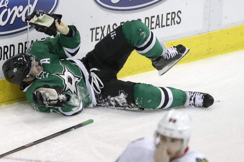 Dallas Stars defenseman Stephane Robidas (3) lies on the ice in pain after injuring his leg...
