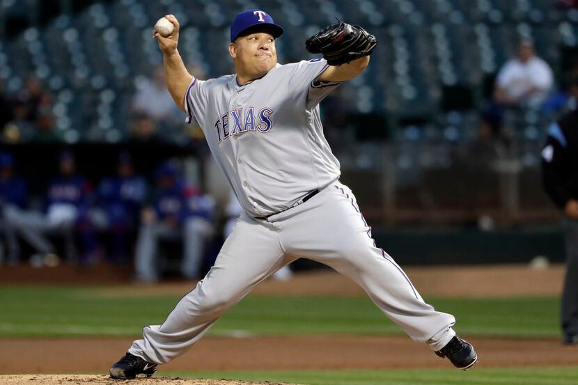 Texas Rangers starting pitcher Bartolo Colon throws to the Oakland Athletics during the...
