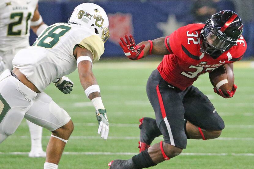 Texas Tech running back Da'Leon Ward (32) gets set to stiff-arm Baylor safety Chance Waz...