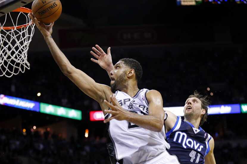 San Antonio Spurs forward Tim Duncan (21) races by Dallas Mavericks forward Dirk Nowitzki...