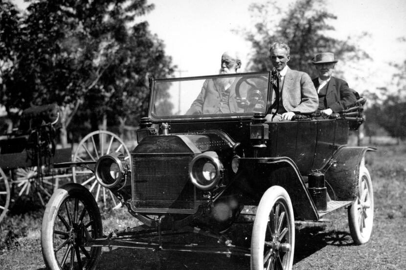 American industrialist Henry Ford (at the wheel) and inventor Thomas Edison, seated in the...