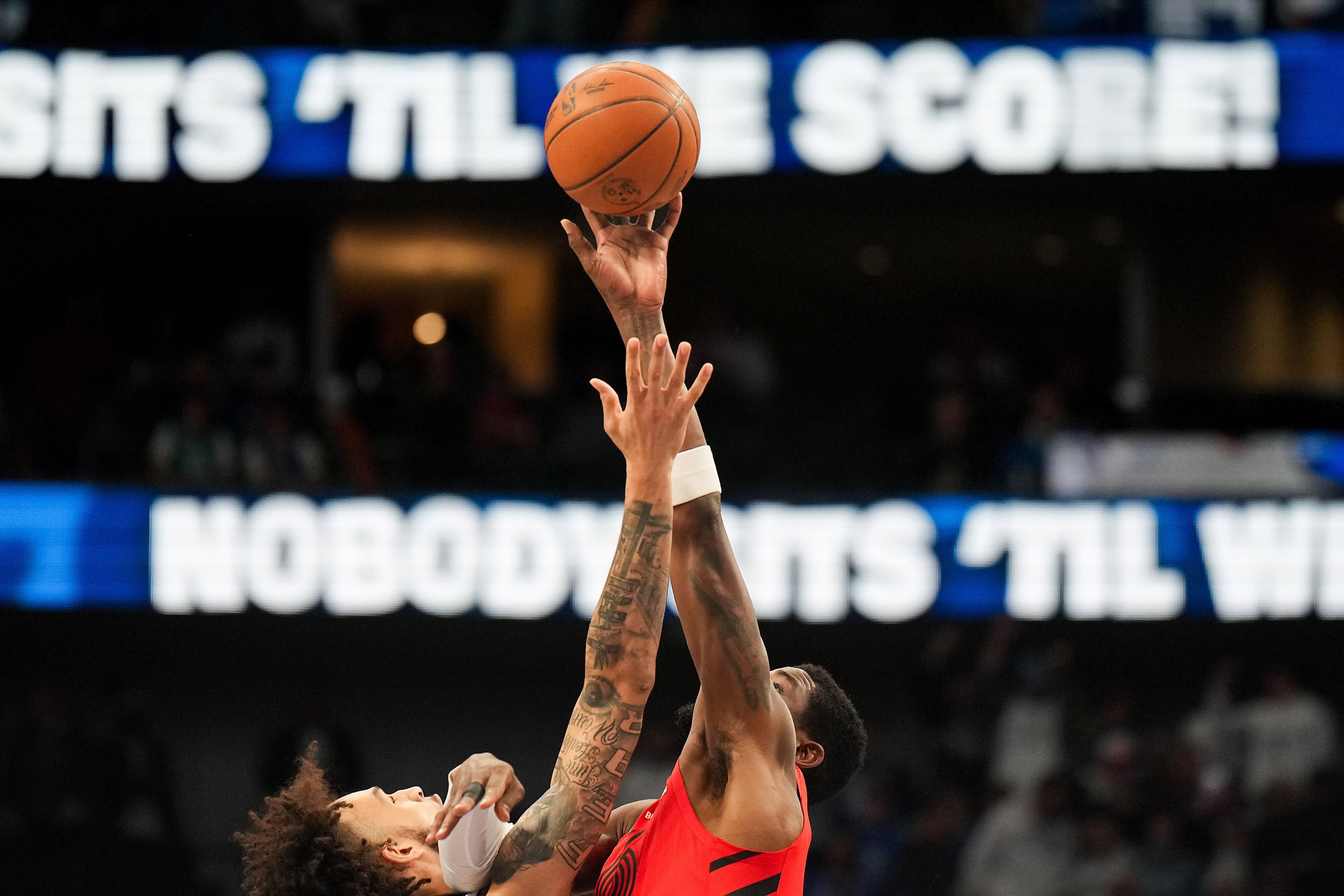 Dallas Mavericks center Dereck Lively II (left) goes for the opening tipoff against Portland...