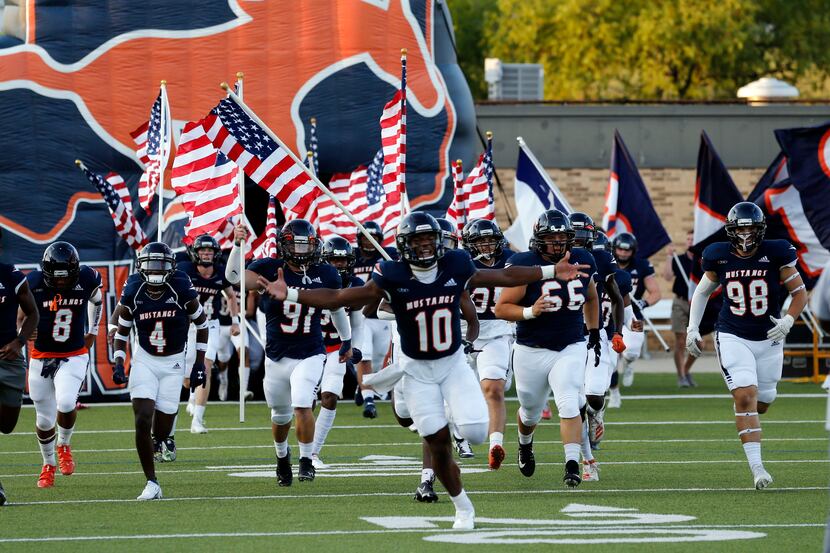 The Sachse High Mustangs run onto the field, led by QB Alex Orji (10), before the first half...