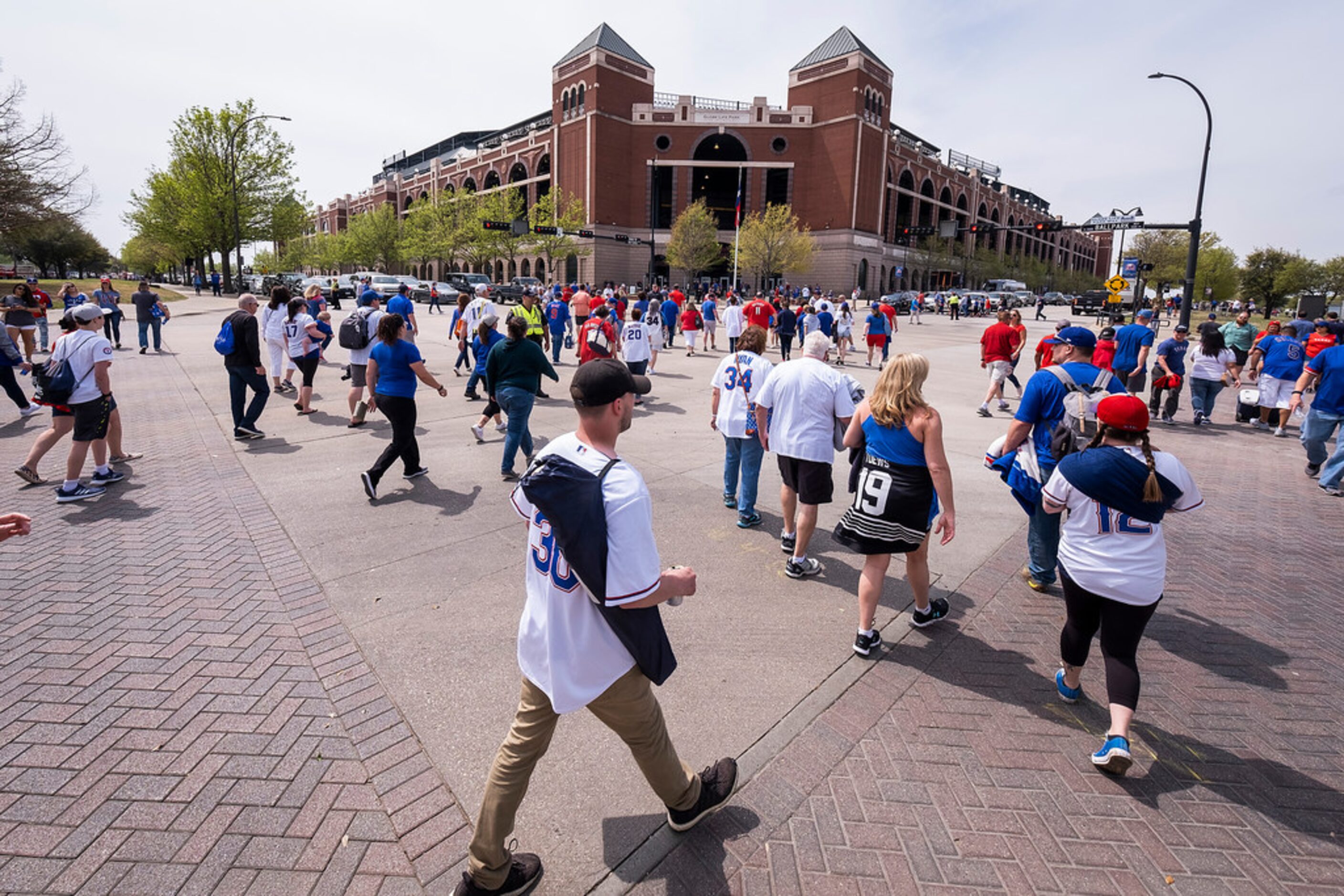 Fans head for the stadium for the Texas Rangers opening day game against the Chicago Cubs at...