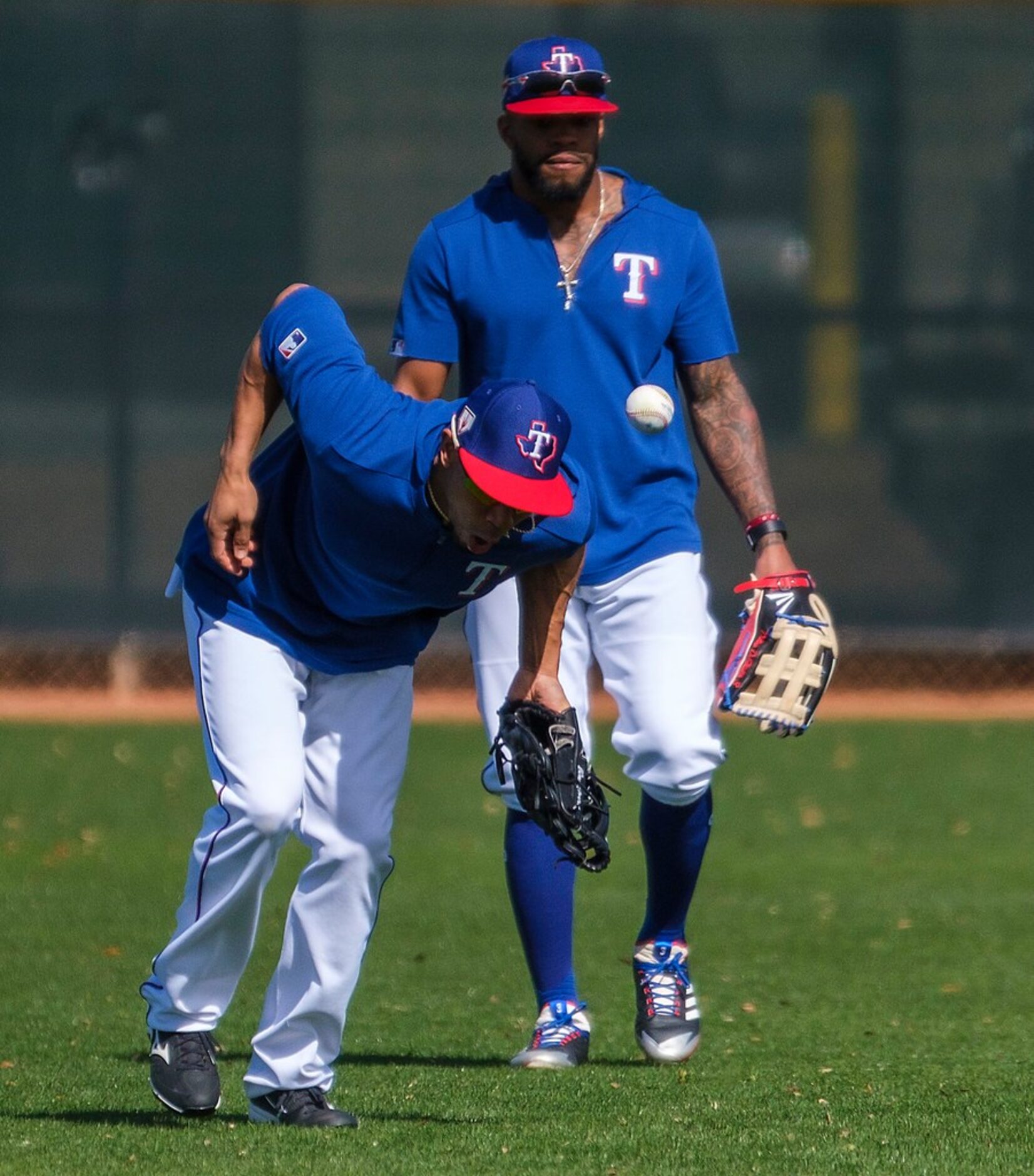 Texas Rangers outfielder Ben Revere (front) participates in a fielding drill with outfielder...