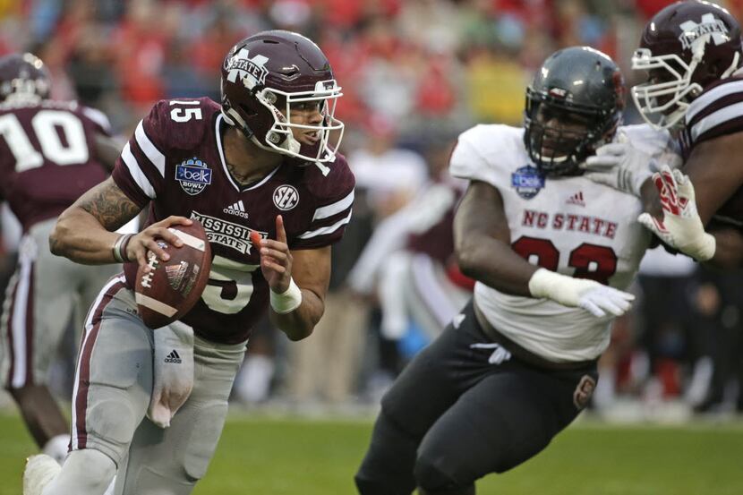 Mississippi State quarterback Dak Prescott (15) scrambles as North Carolina State defensive...