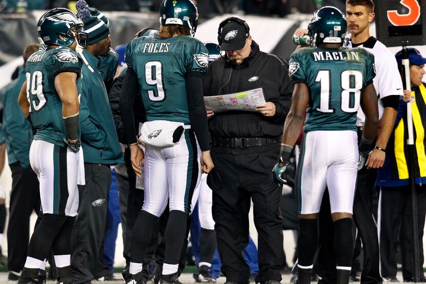Eagles head coach Andy Reid huddles with quarterback Nick Foles (9), wide receiver Jeremy...