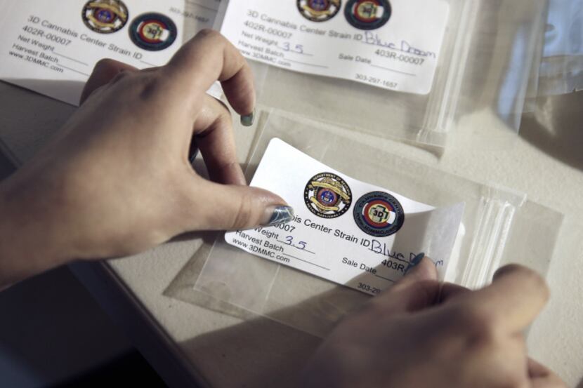An employee labels packages of pot to be sold at 3D Cannabis Center in Denver.