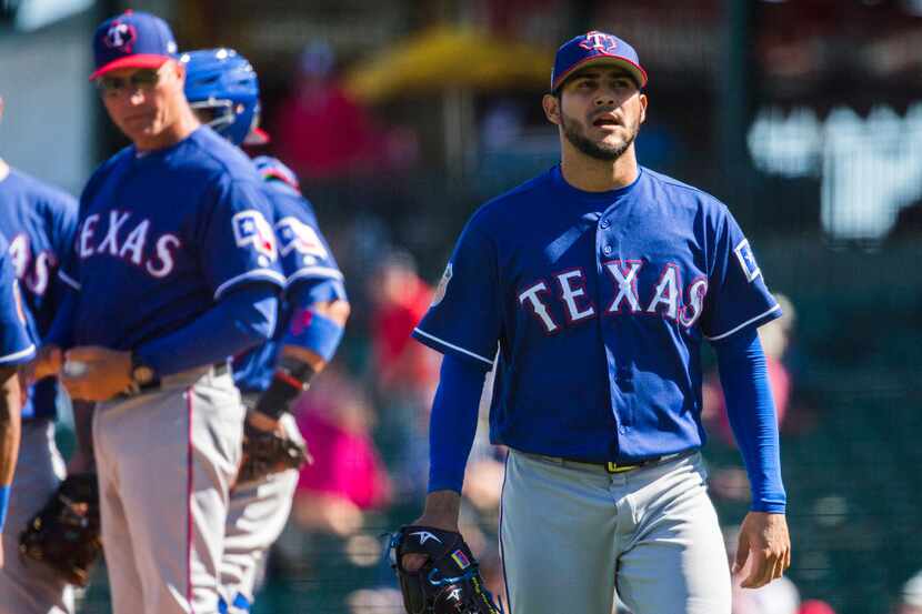 Texas Rangers starting pitcher Martin Perez (33) walks back to the dugout after being pulled...