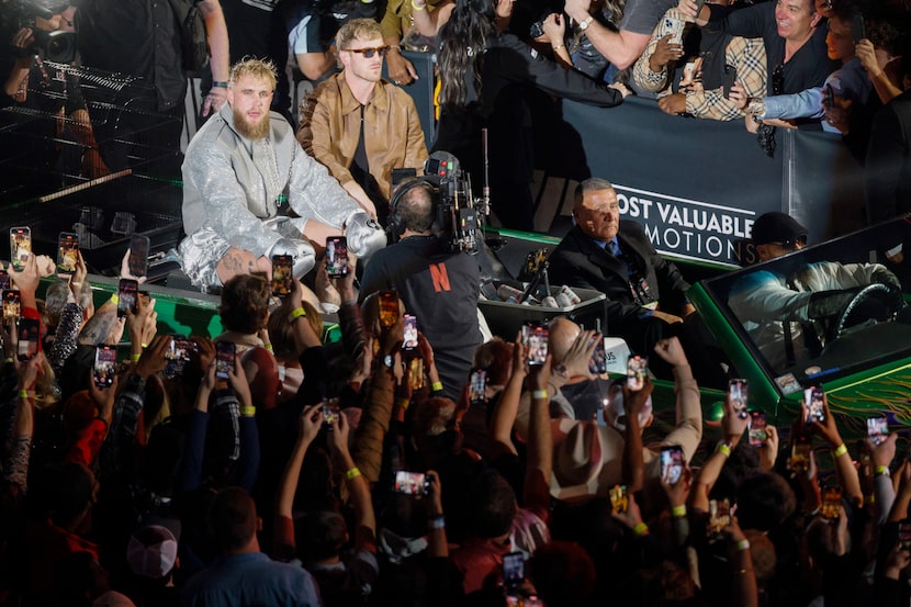 Jake Paul (left) rides on the back of a car with his brother Logan Paul before a heavyweight...