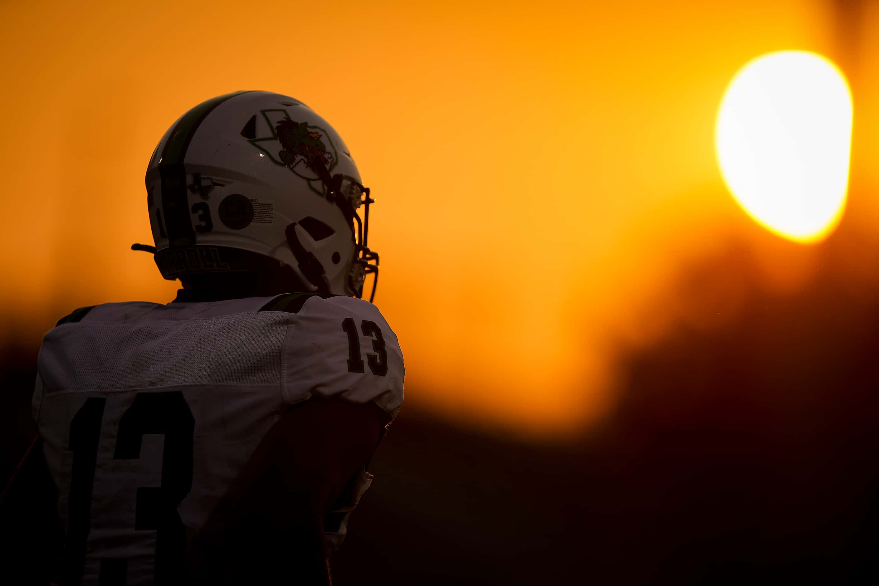 Southlake Carroll wide receiver RJ Maryland heads to the huddle as the sun sets during the...