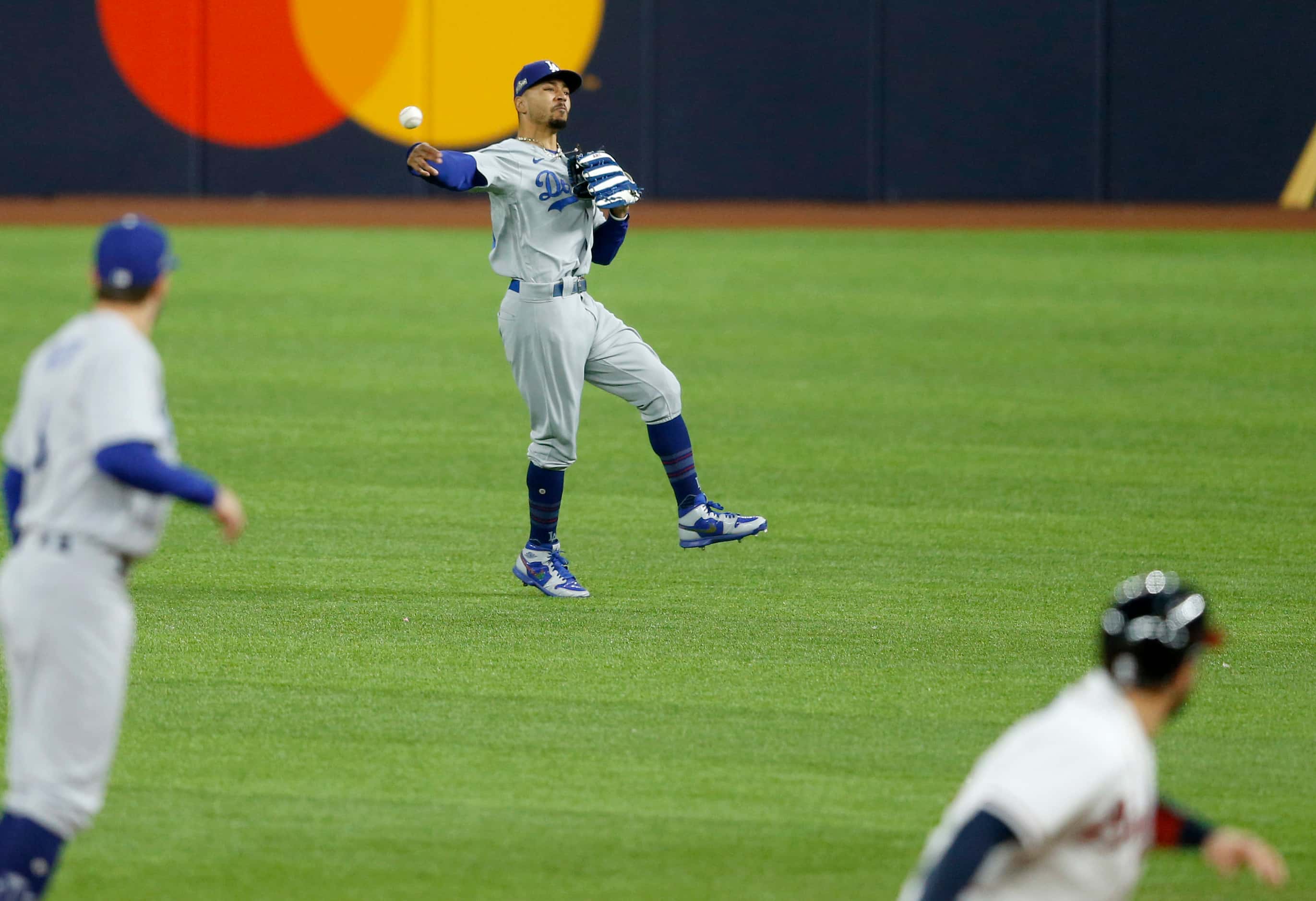 Los Angeles Dodgers right fielder Mookie Betts (50) throws home after catching a fly ball...