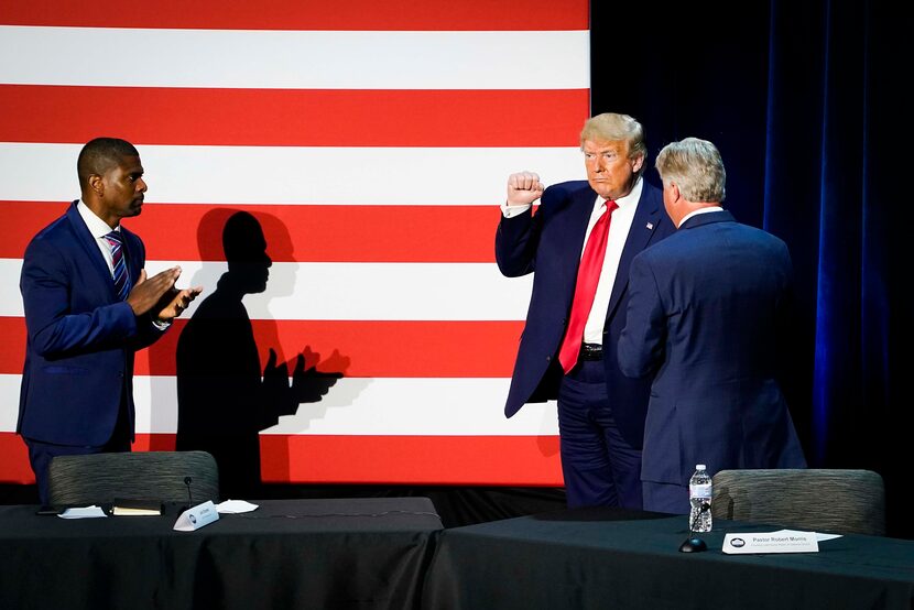 Jack Brewer (left) applauds as President Donald Trump acknowledges the crowd at the...