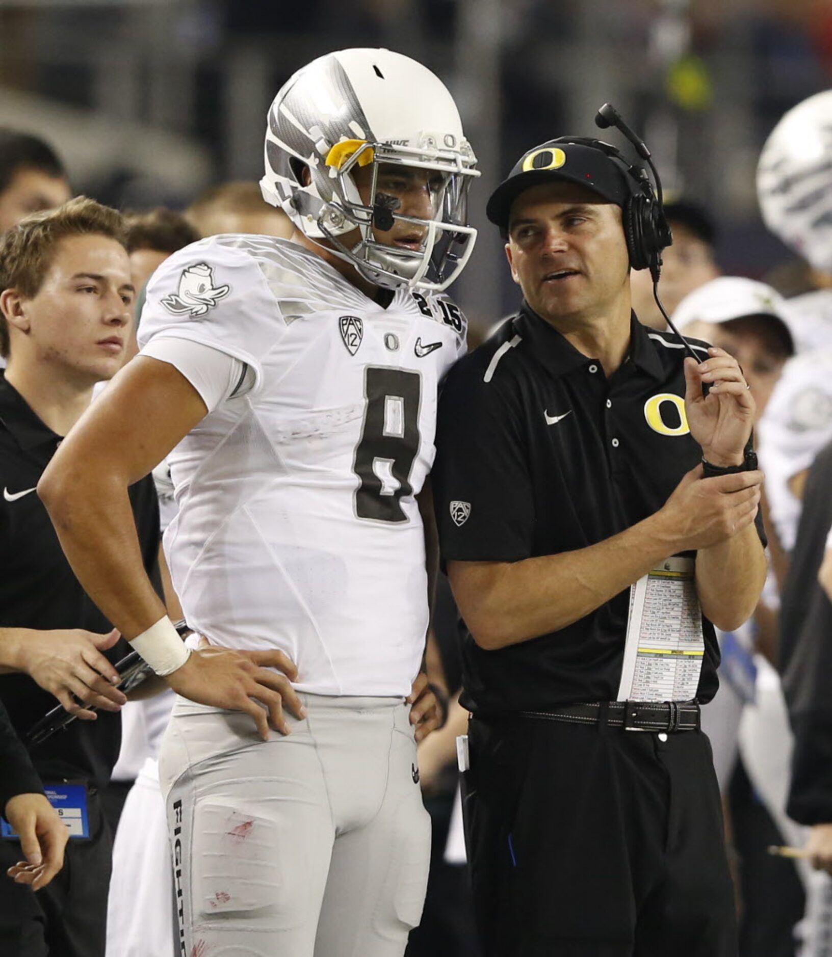 Oregon Ducks head coach Mark Helfrich talks to Oregon Ducks quarterback Marcus Mariota (8)...