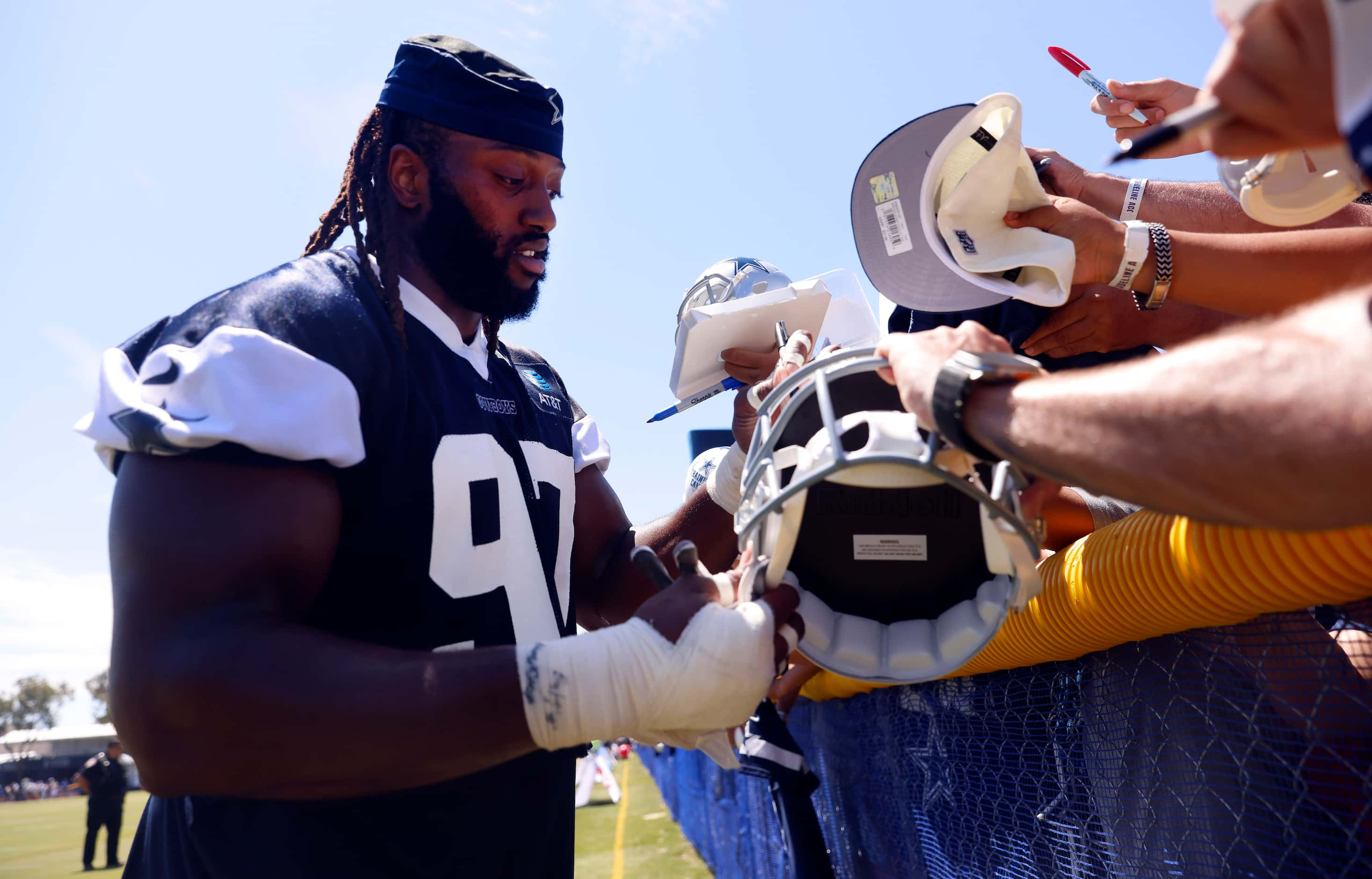 Dallas Cowboys defensive tackle Osa Odighizuwa (97) signs autographs for fans following...