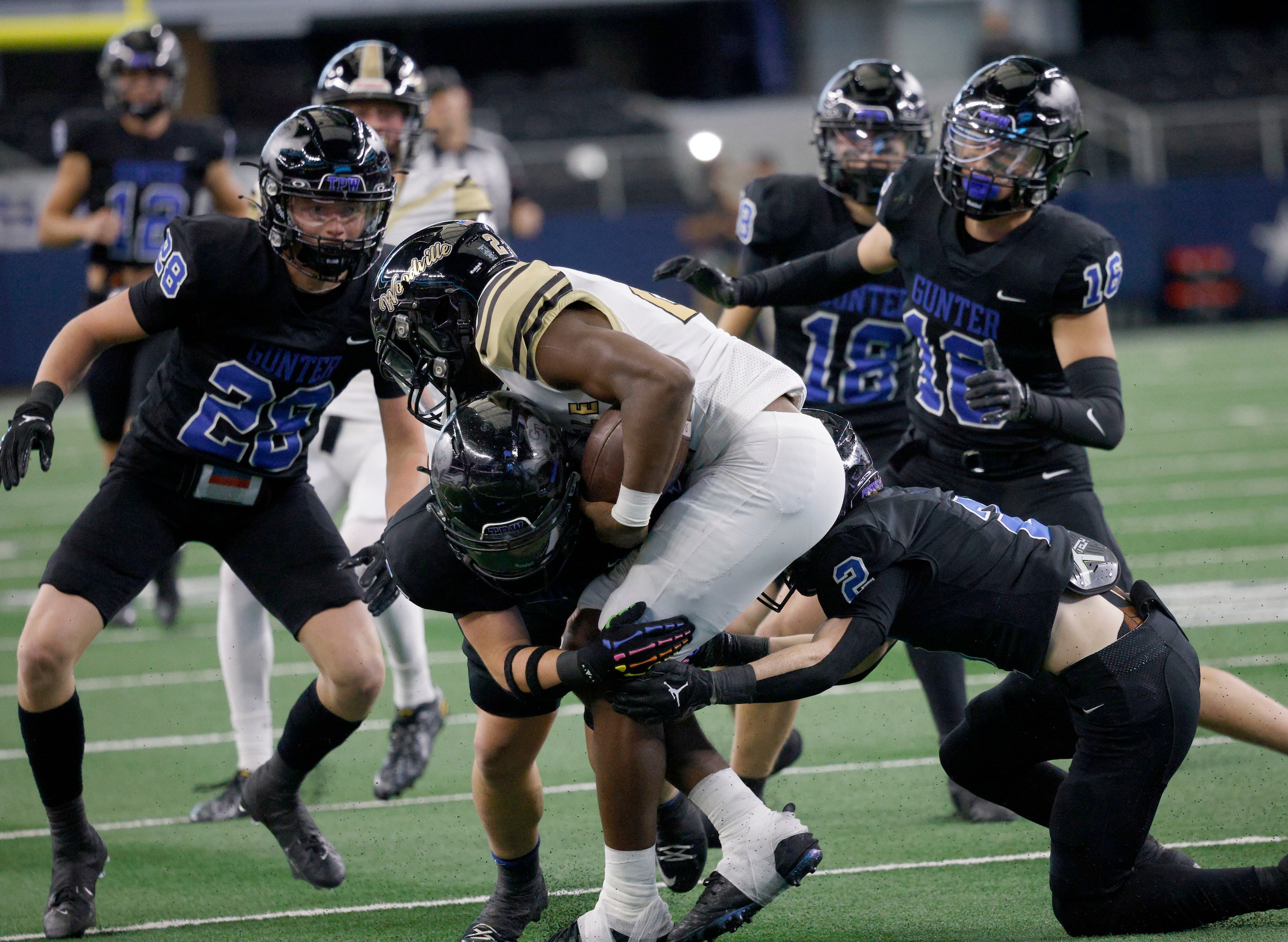 Woodville's Adailius Williams (21) is tackled by Gunter's  Jax Graham (11) and Gunter's ...