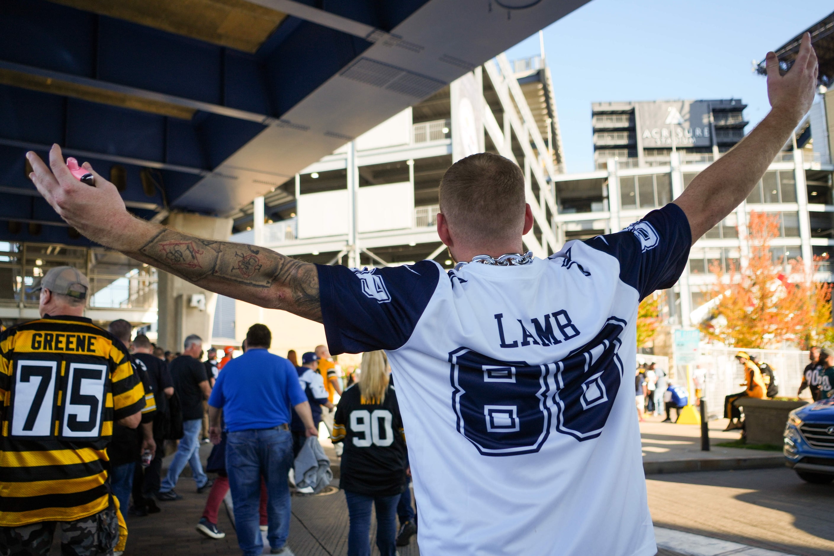 A Dallas Cowboys fan wears a CeeDee Lamb #88 jersey as he heads into the stadium before an...