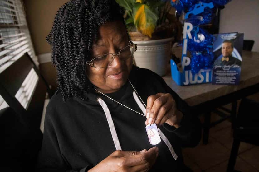 Dorothy Claiborne looks at her necklace, which bears an image of her son, Justin Allen, 28,...