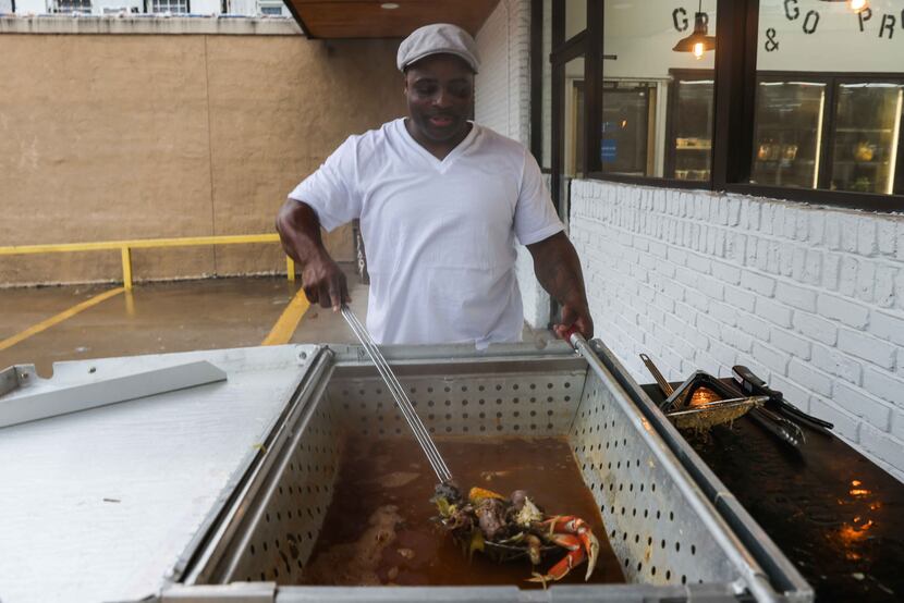 Eugene Vessel, owner of Sweet Grass Market, mixes up gumbo in front of the shop.