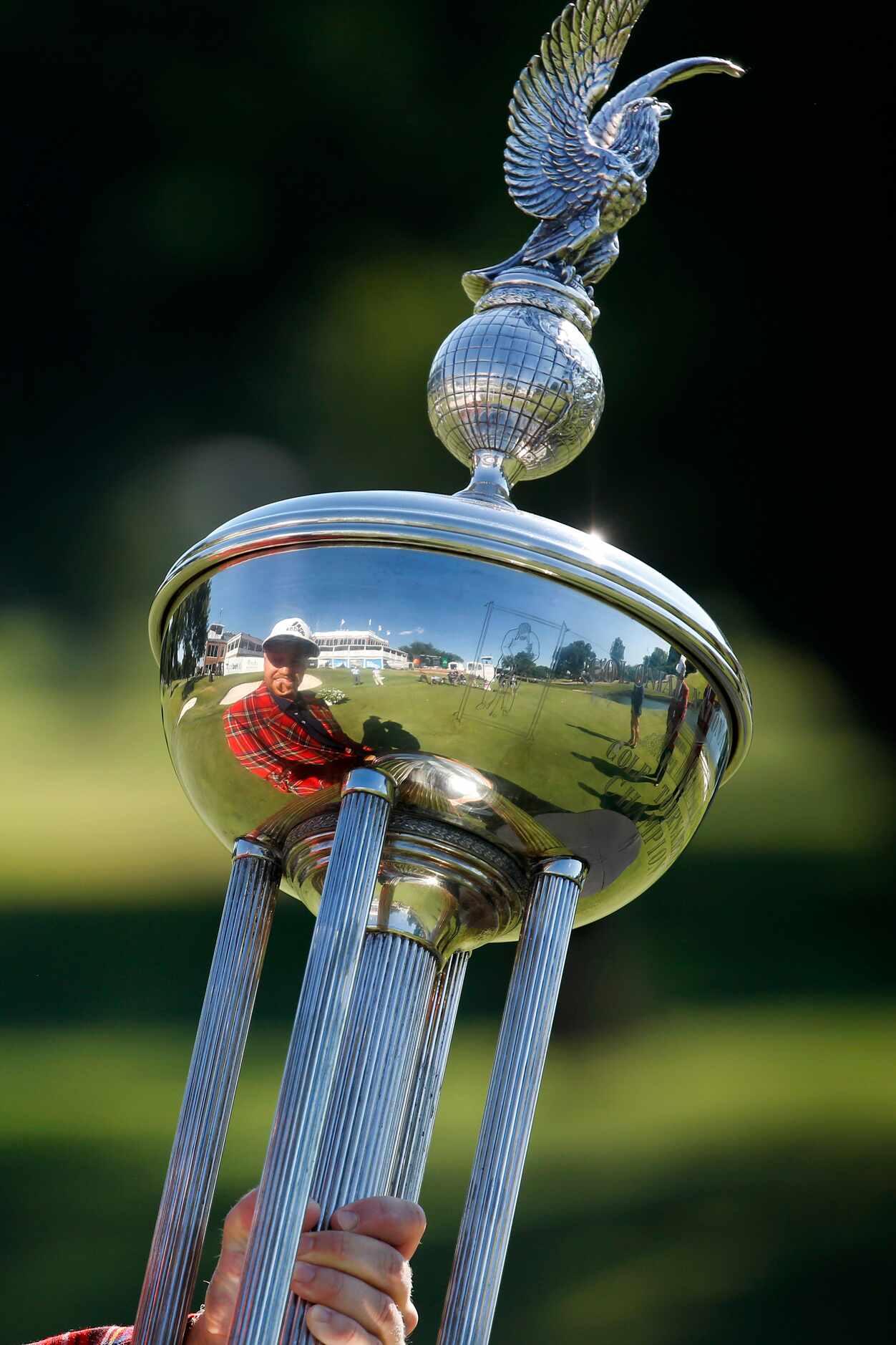 On the 18th green, PGA Tour golfer Daniel Berger looks at himself reflected in the winning...
