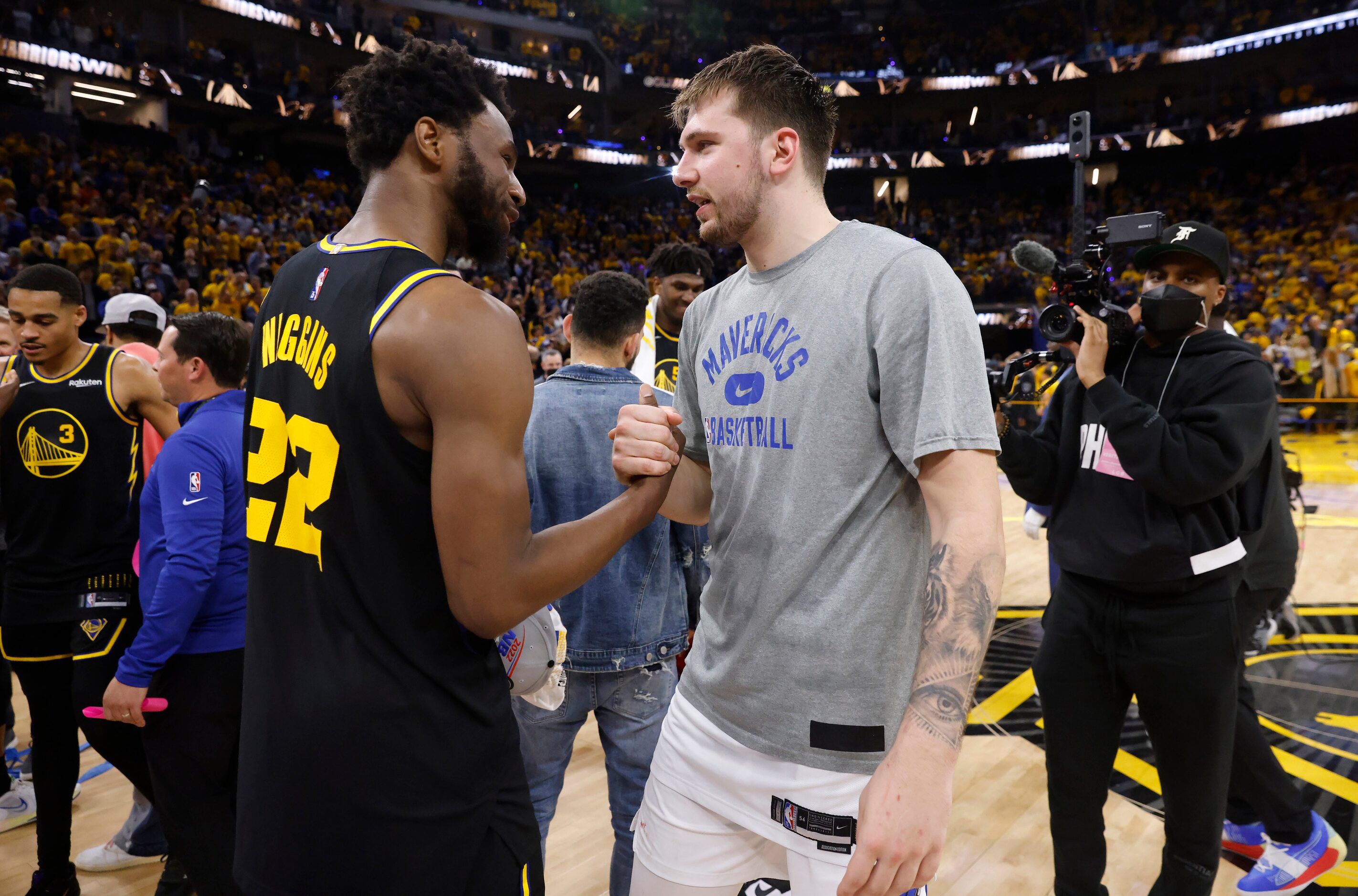 Dallas Mavericks guard Luka Doncic (center) congratulates Golden State Warriors forward...