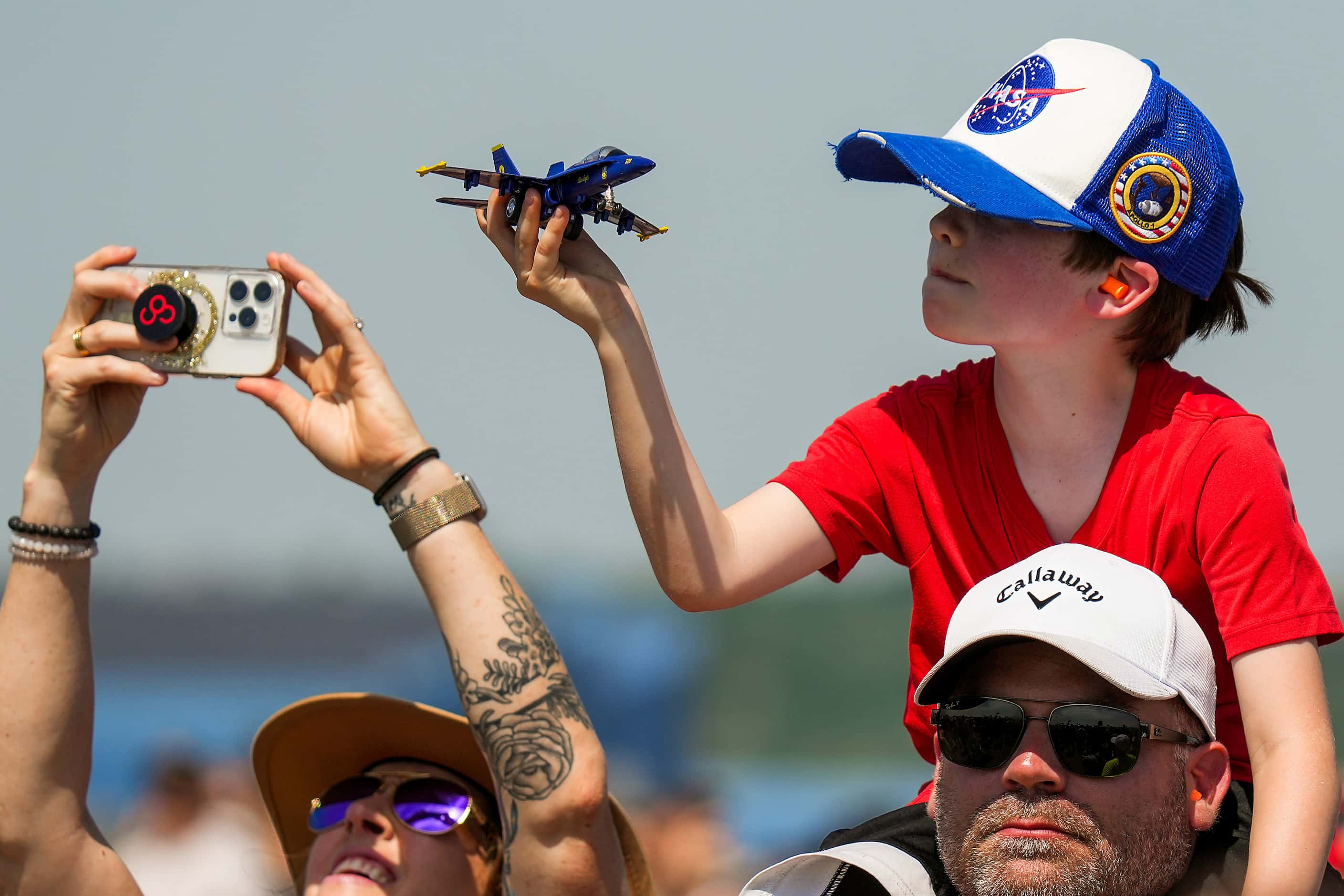 Keaston Lee, 8, sits atop the shoulder of his father Aron Lee to watch the Blue Angels...