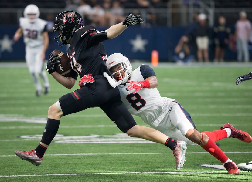 Allen defensive back TKai Lloyd (8) brings down Lake Travis kick returner Nathan Parodi (14)...