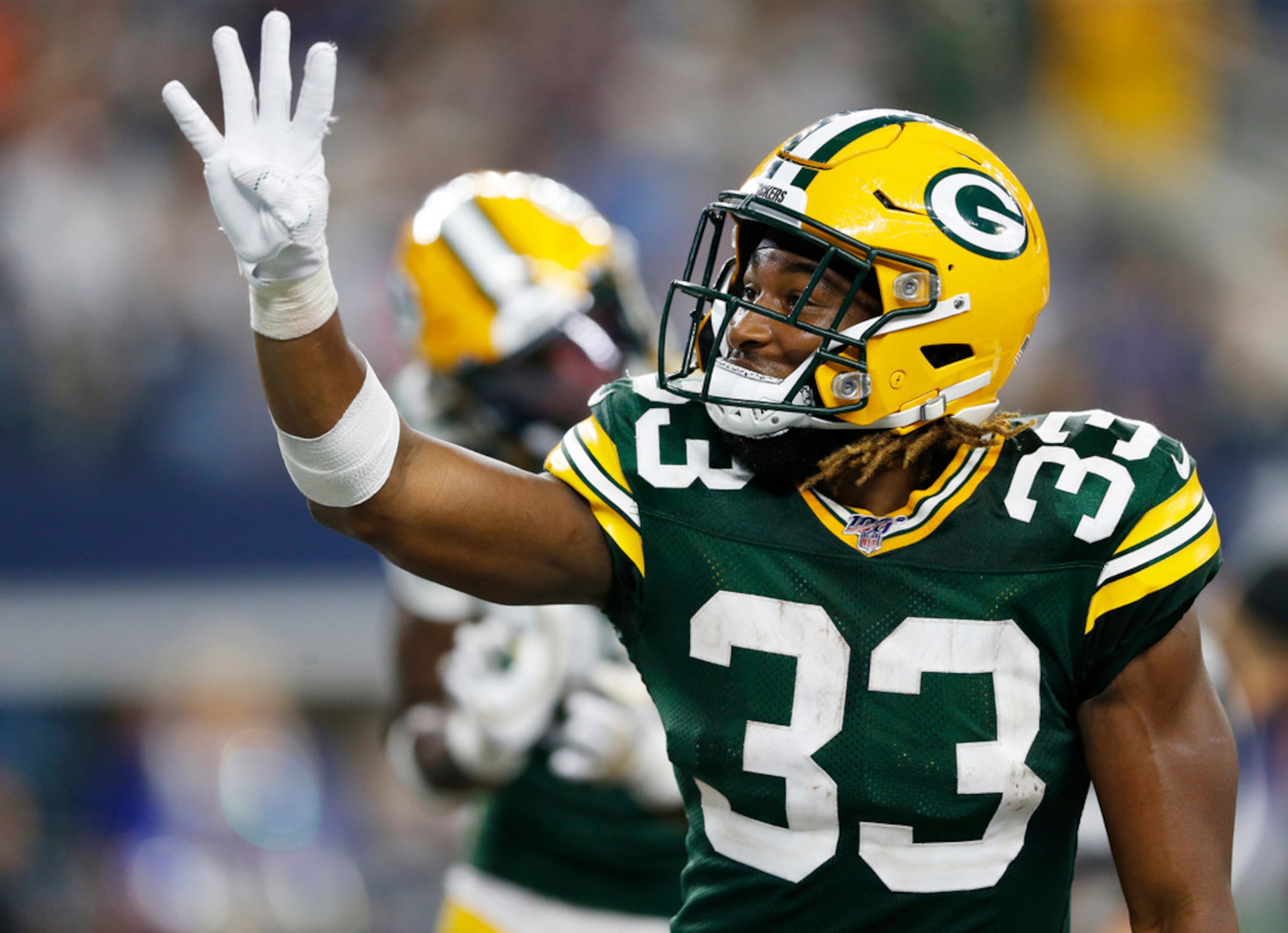 Green Bay Packers running back Aaron Jones (33) signals his fourth touchdown after scoring...