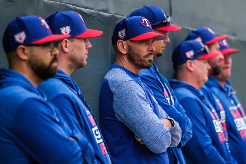 Texas Rangers manager Chris Woodward watches a bullpen session with coaches and staff during...