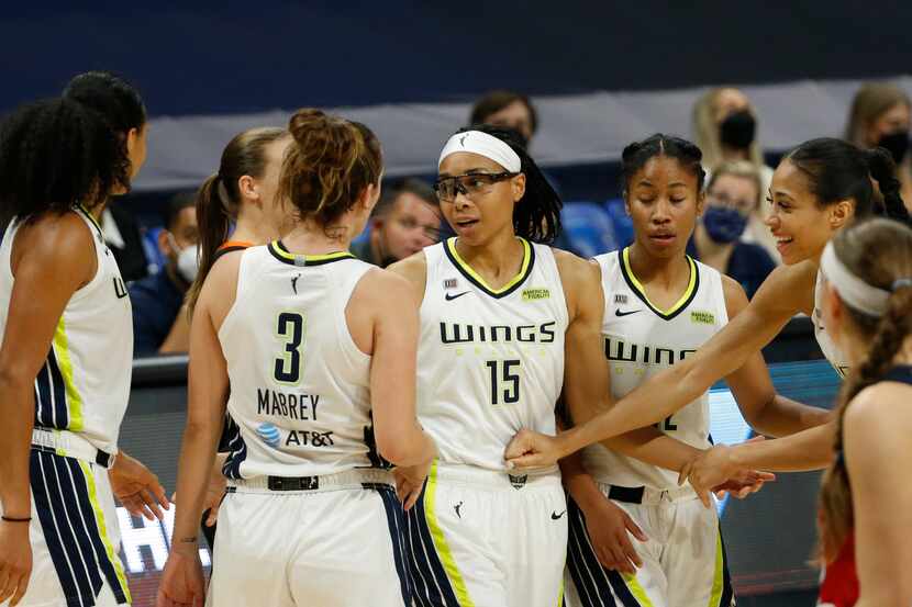 Teammates celebrate Dallas Wings guard Allisha Gray (15) after a made basket and called foul...