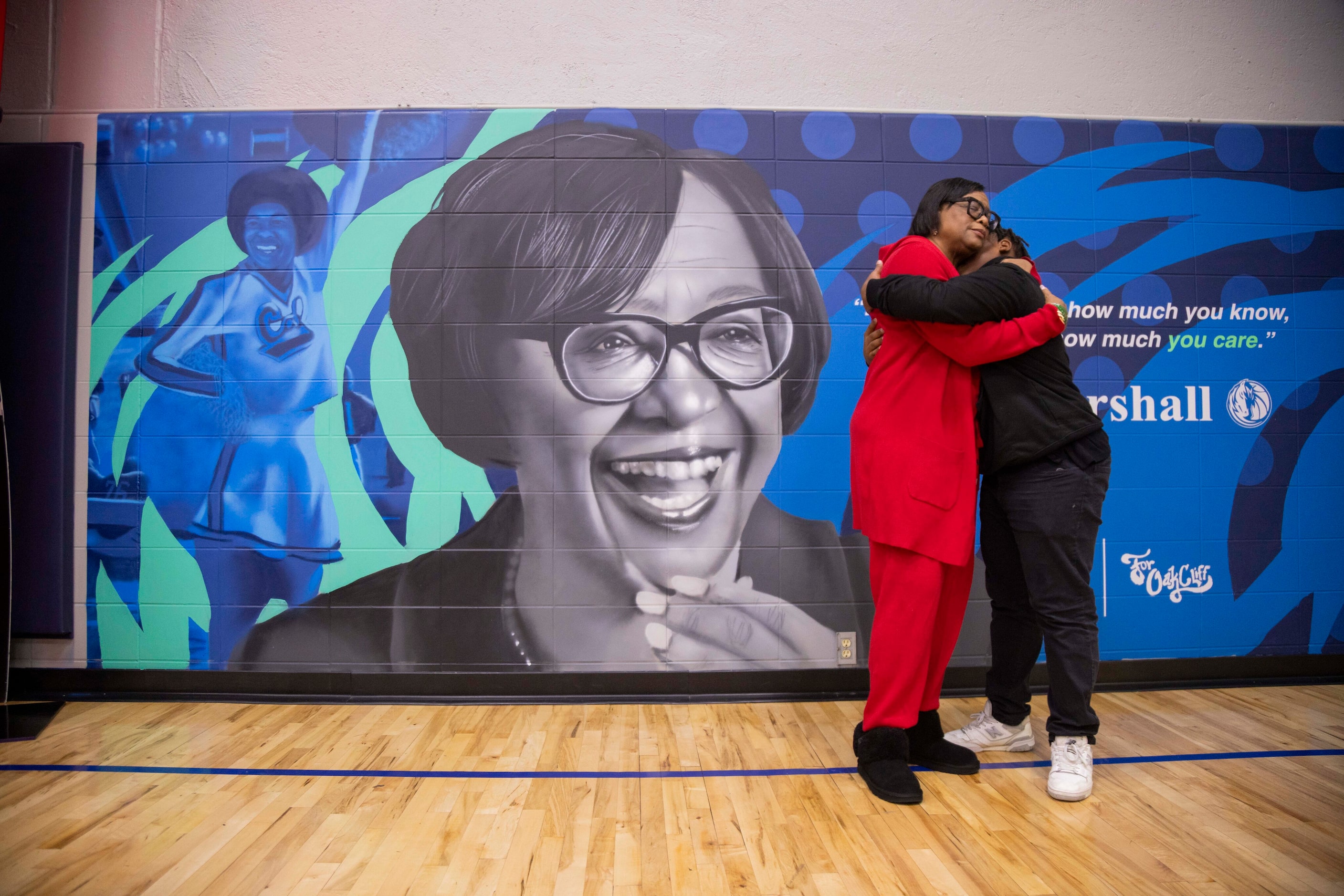 (From left) Cynt Marshall, chief executive officer of the Dallas Mavericks, hugs Justin Poe,...