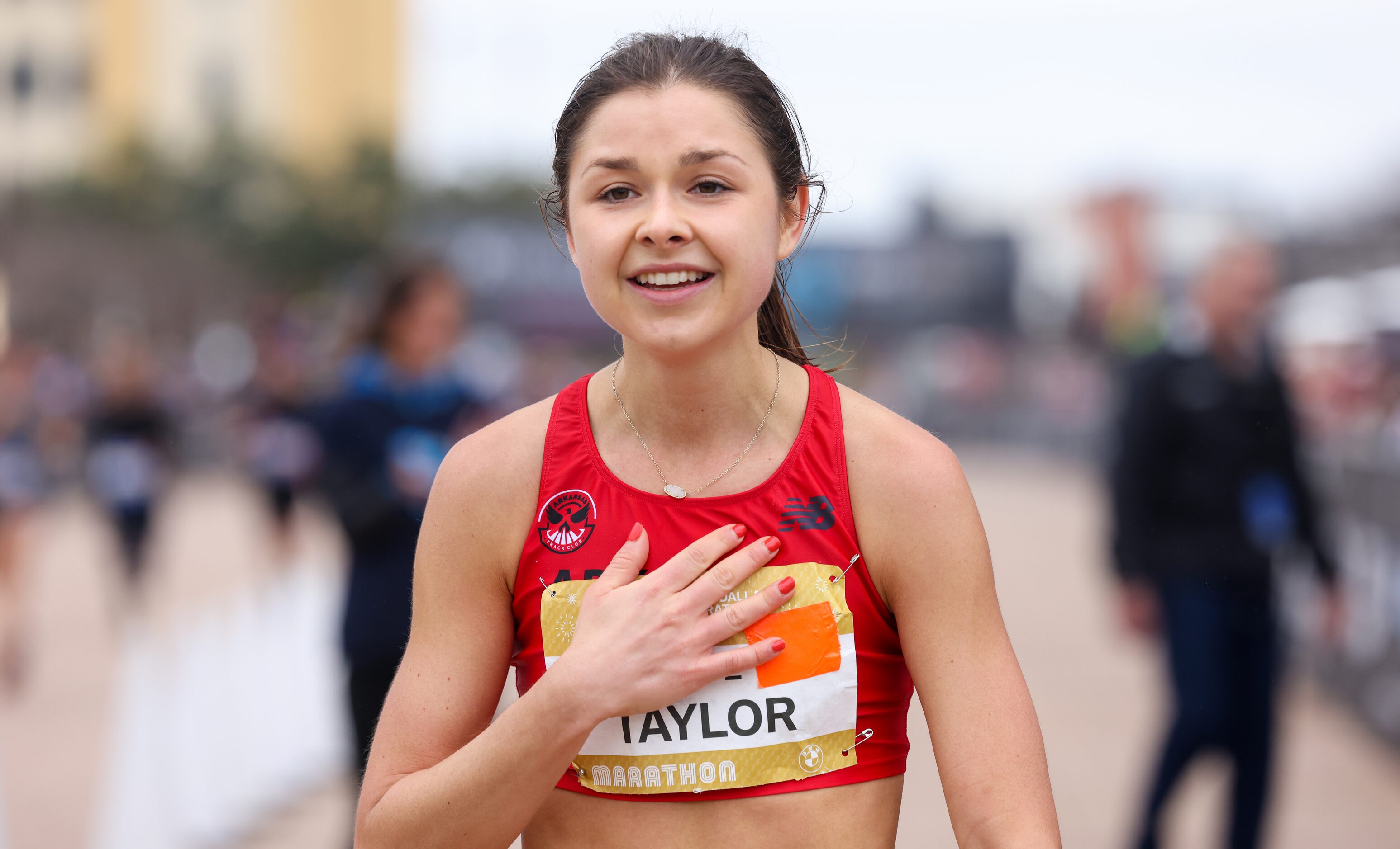 Megan Taylor places a hand on her chest after crossing the BMW Dallas Marathon finish line...