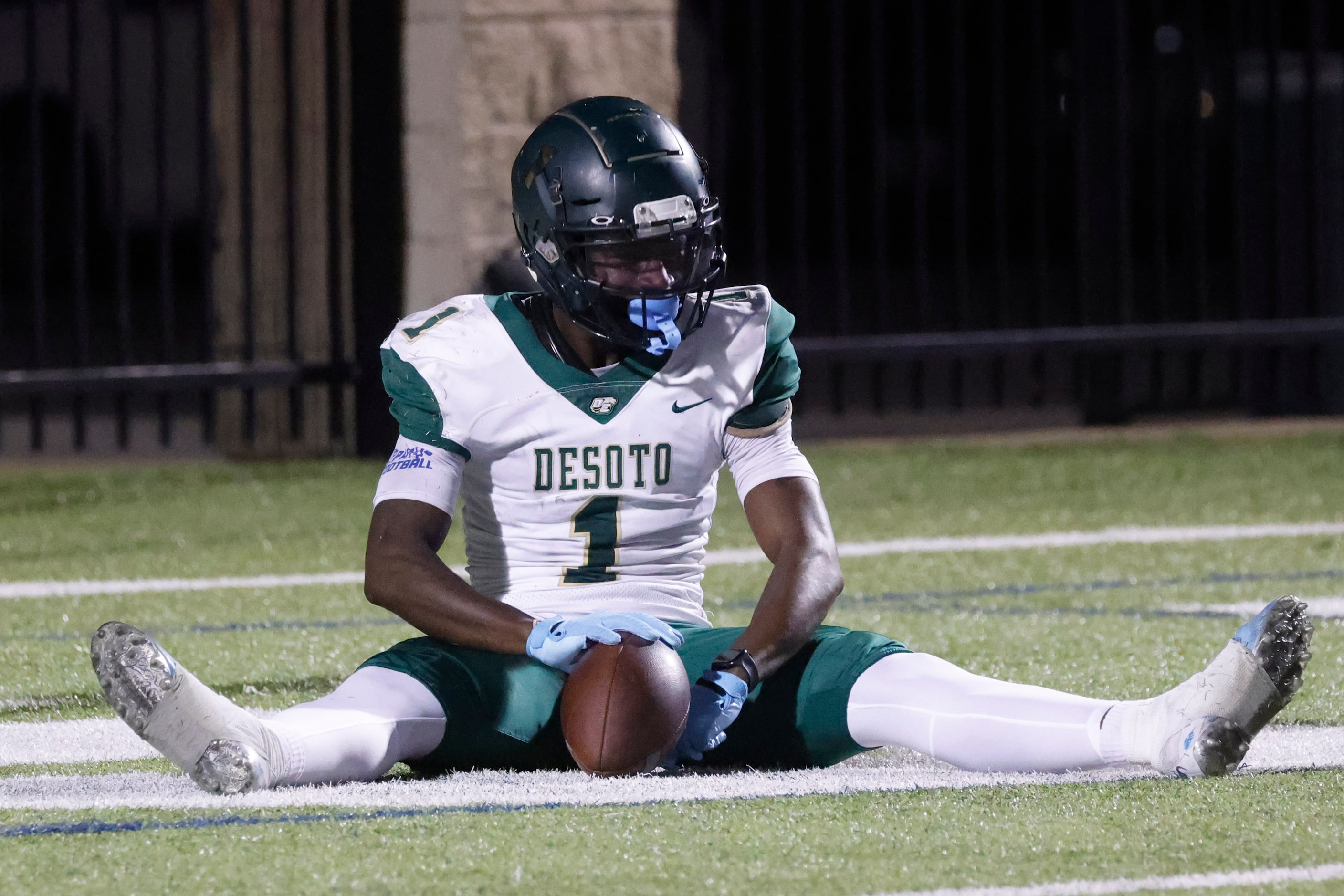 DeSoto High School’s Johntay Cook II (1) sits on the field as she celebrates a touchdown...