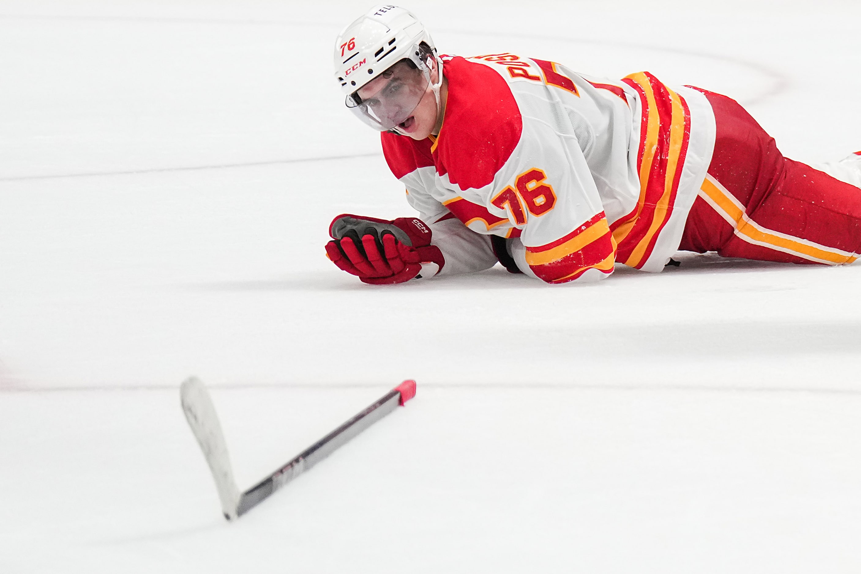 Calgary Flames center Martin Pospisil is slow to get up after taking a hit to the face...