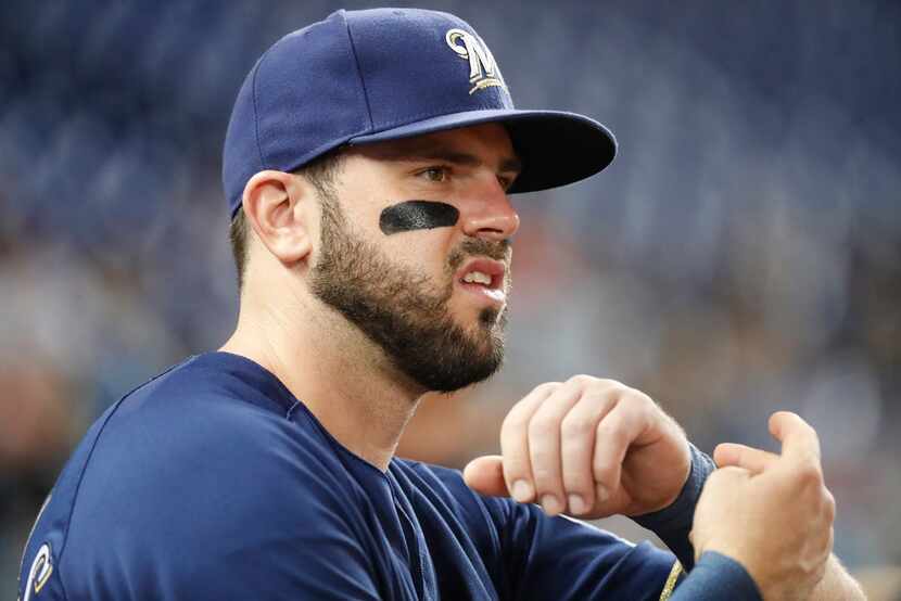 Milwaukee Brewers' Mike Moustakas looks out from the dugout during the fifth inning of a...