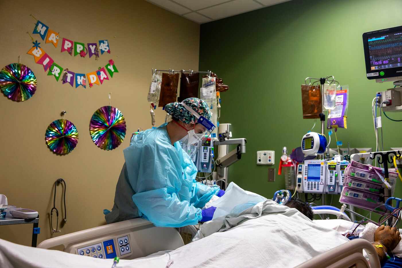 Registered Nurse Alexa Kehoe cares for an intubated intensive care patient whose birthday...