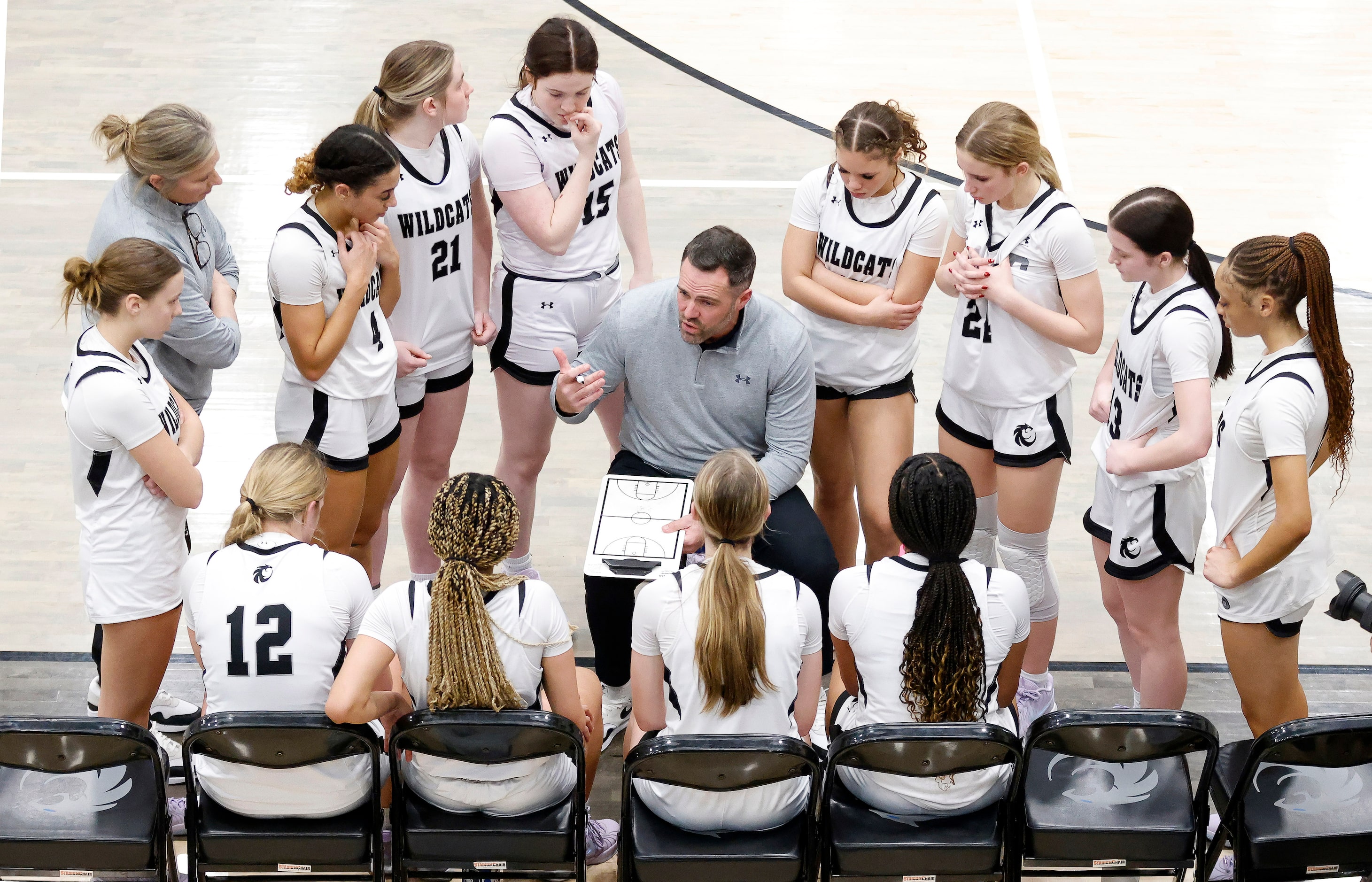 Denton Guyer head coach Jake Floyd (center) gathers his players for instruction late in the...