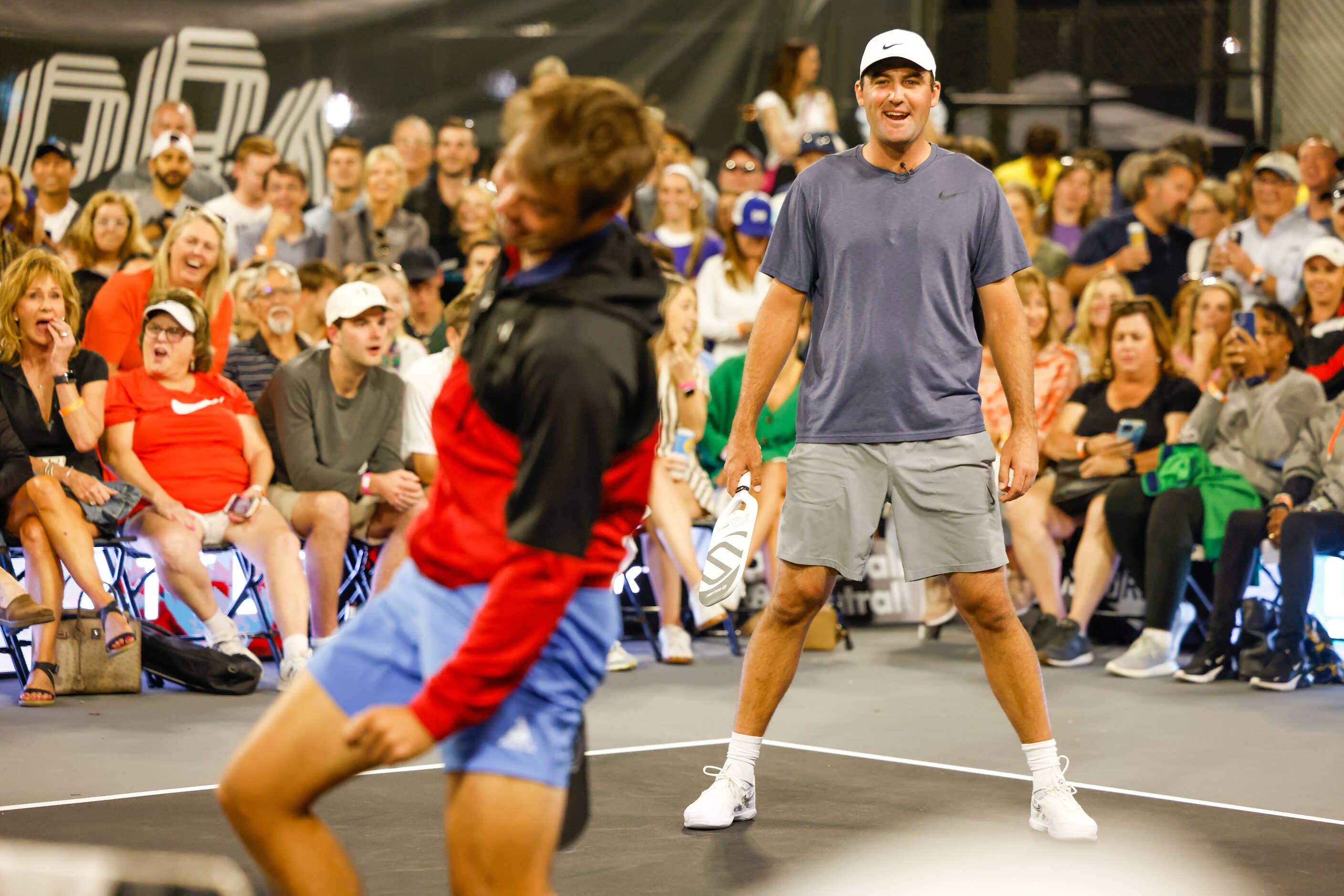 Ben Johns (left) swings his paddle as Scottie Scheffler watches during a doubles match of...