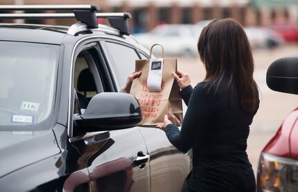 Deena Chavoya-Abeyta, co-owner of butcher shop Deep Cuts Dallas, hands off a to-go order to...